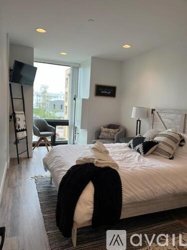 A bedroom with a large bed and a chair.