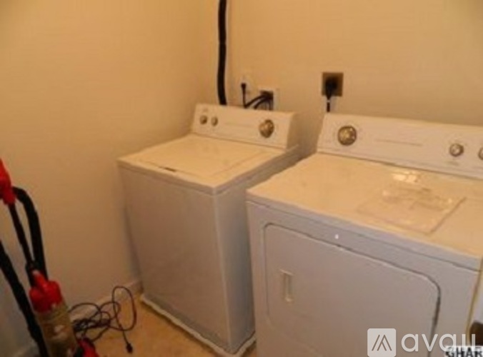 Two white front loading washing machines in a small room.