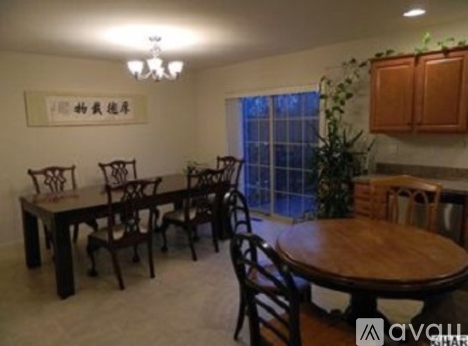 A dining room with a wooden table and chairs.
