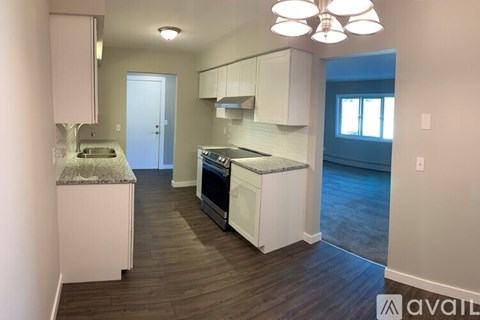 A kitchen with white cabinets and a grey countertop.
