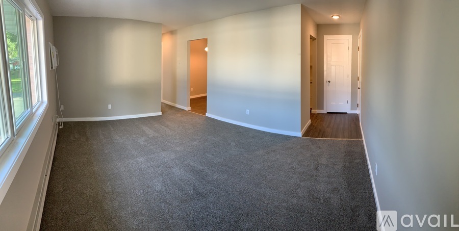 Empty room with carpeted floor and two doors.