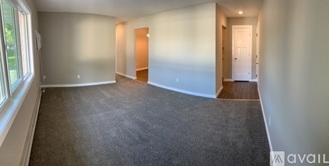 Empty room with carpeted floor and two doors.