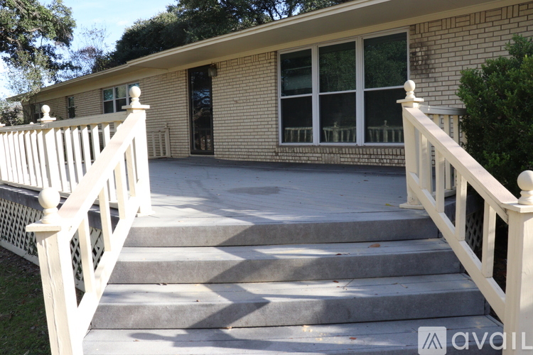 A house with a white fence and steps leading to the front door.