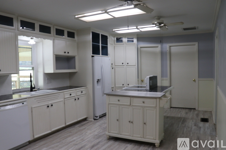 A kitchen with white cabinets and appliances is available for rent.
