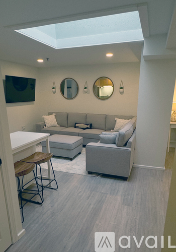 A living room with a grey couch and a white table.