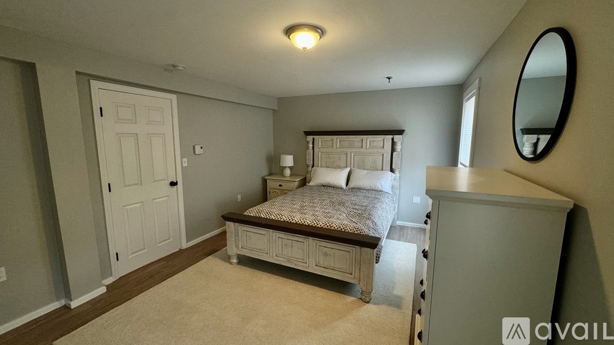 A bedroom with a bed, dresser, and mirror.