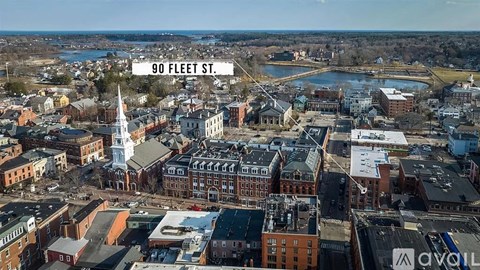 A cityscape with buildings and a church steeple is visible from a high vantage point.