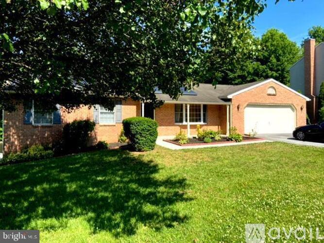 A house with a garage and a tree in front.