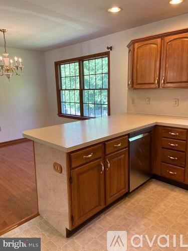 A kitchen with wooden cabinets and a marble countertop.