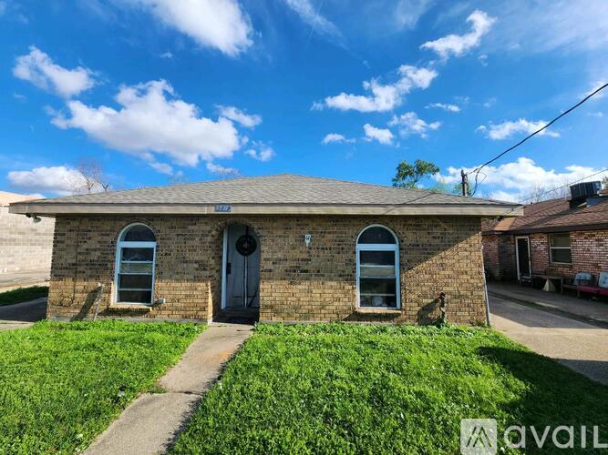 A small brick house with a blue door and windows.