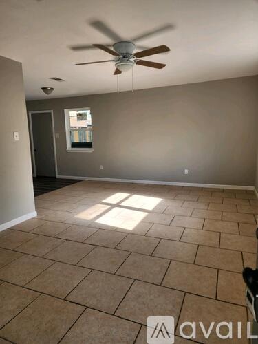 A room with a ceiling fan and tile flooring.