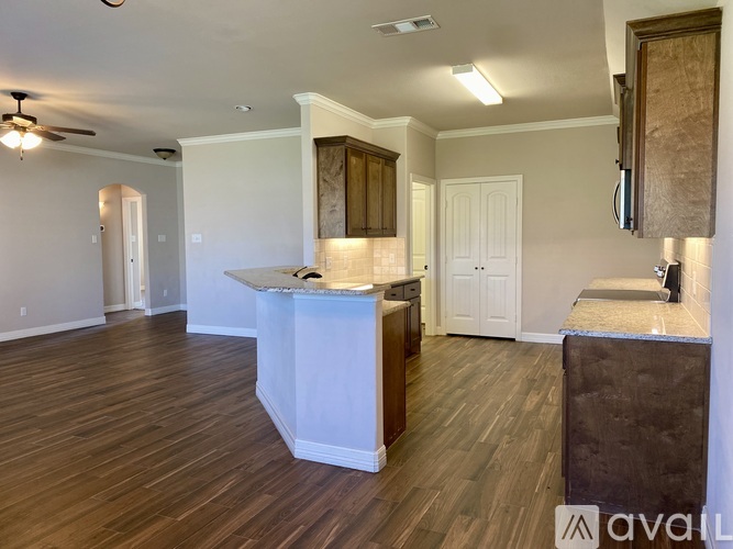 A kitchen with a white island and wooden floors.