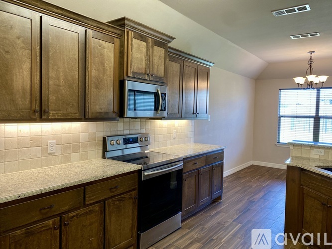A kitchen with wooden cabinets and a granite countertop.