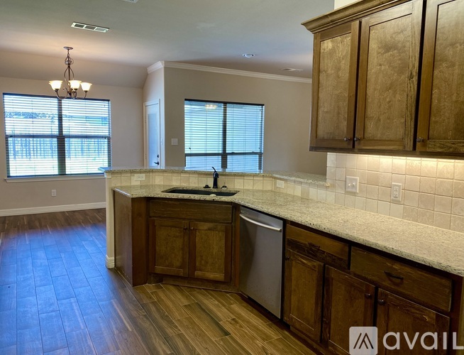 A kitchen with wooden cabinets and a marble countertop.