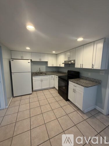 A kitchen with white cabinets and appliances.