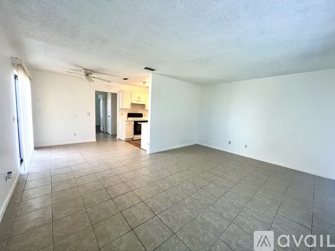 A spacious room with tiled flooring and a ceiling fan.