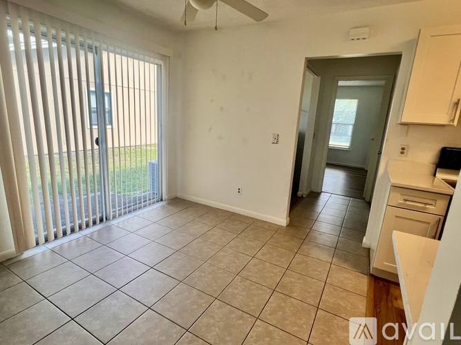 A living room with a sliding glass door and a tiled floor.