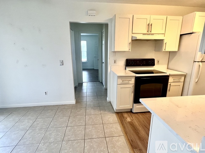 A kitchen with white cabinets and appliances.