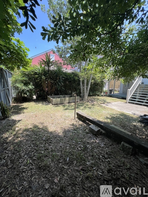 A backyard with a wooden deck and a tree.
