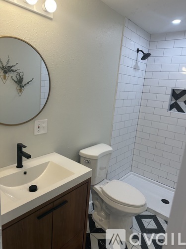 A bathroom with a sink, toilet, and a mirror.