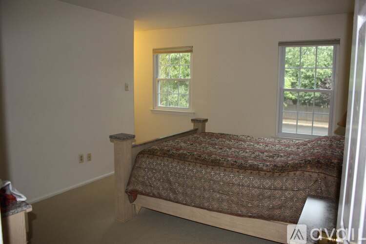 A bedroom with a bed and a window.