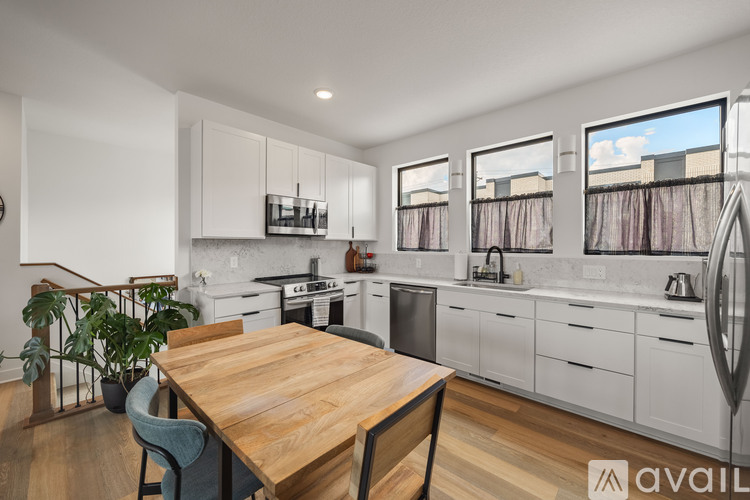 A kitchen with a wooden table and chairs, and a stove top oven.