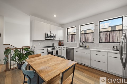 A kitchen with a wooden table and chairs, and a stove top oven.