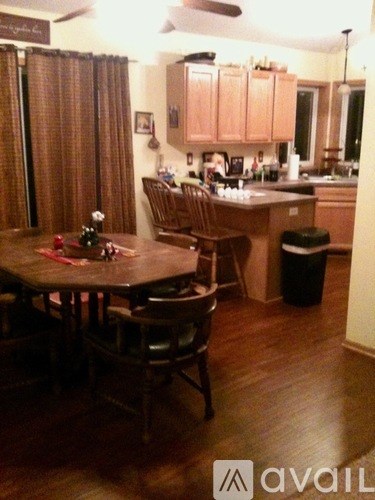 A kitchen with a table and chairs in front of it.