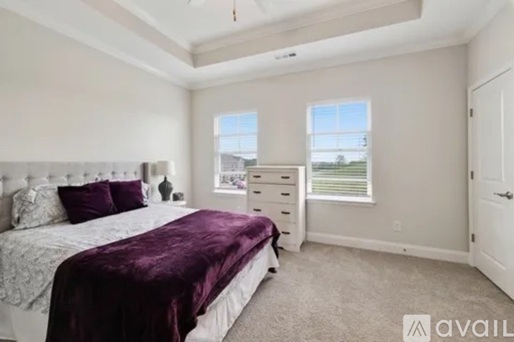 A bedroom with a large bed and a window.