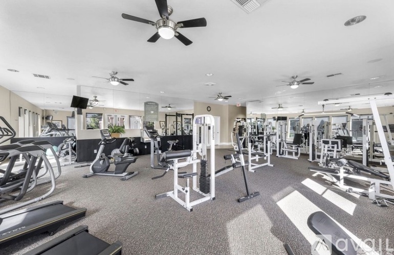 A spacious gym with a variety of equipment including treadmills, weights, and exercise machines.