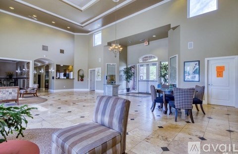 A living room with a striped couch and a dining table with chairs.