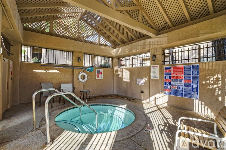 A hot tub in a room with a warning sign on the wall.