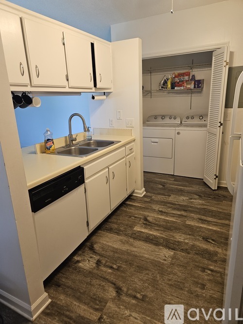 A kitchen with white cabinets and a sink.