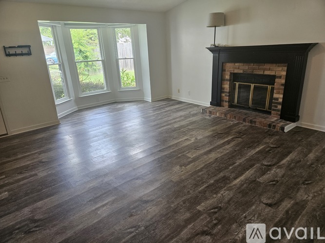 A living room with a fireplace and wood flooring.