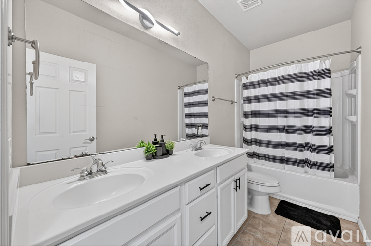 A bathroom with a white sink and a white toilet.