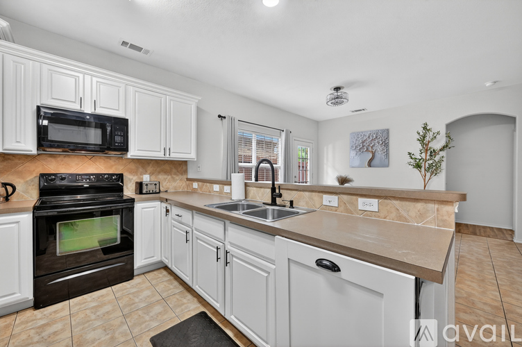A kitchen with white cabinets and a black oven.