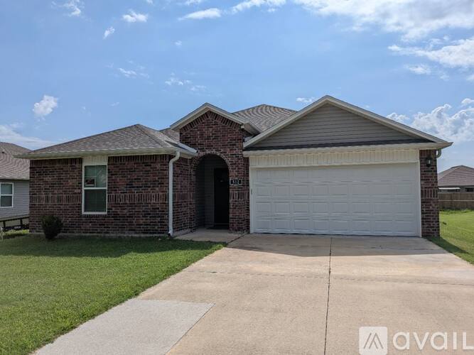 A brick house with a garage door that is open.