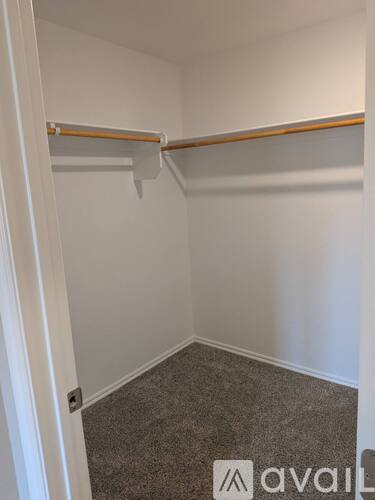 A small, empty room with a carpeted floor and a single shelf.