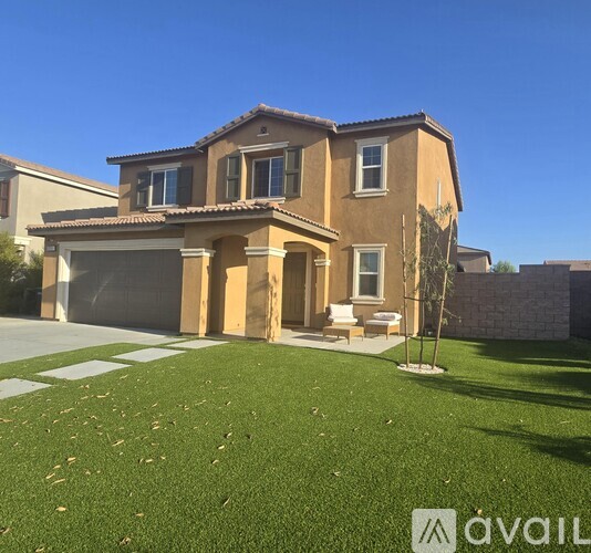 A house with a brown exterior and a green lawn in front.