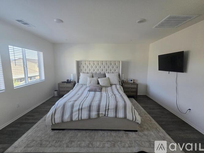A bedroom with a large bed and a flat screen TV mounted on the wall.