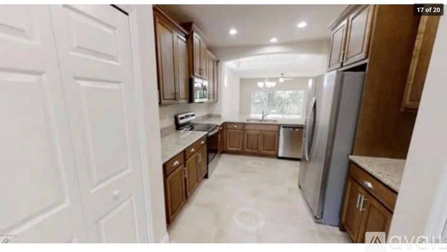 A kitchen with white cabinets and a refrigerator.