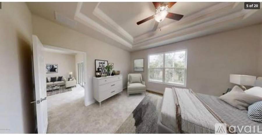 A bedroom with a large bed and a ceiling fan.