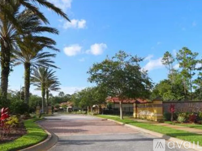 A street view with palm trees and a building in the background.