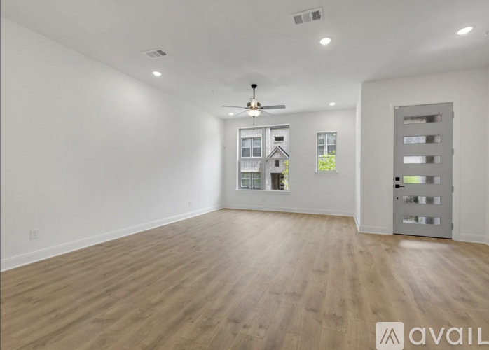 A spacious room with wooden flooring and a ceiling fan.