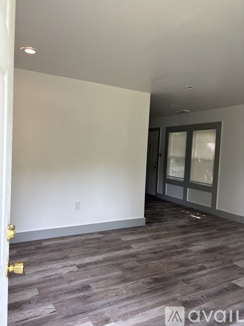 A room with wooden flooring and a white wall.