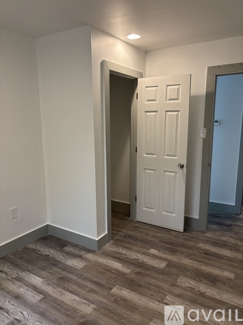 A room with a white door and a grey floor.