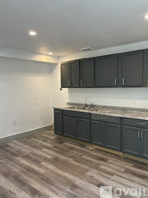 A kitchen with dark wood cabinets and a white countertop.