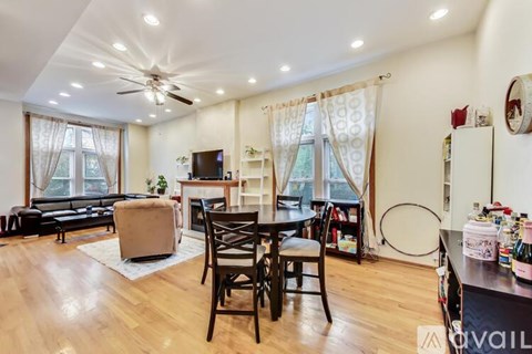 A living room with a black table and chairs, a white couch, and a television.