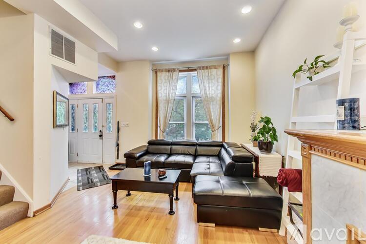 A living room with a black leather couch and a coffee table.