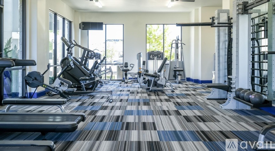 A gym with a variety of equipment including treadmills, weights, and exercise machines.